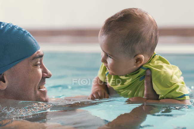 Father with baby boy in public swimming pool. — Stock Photo