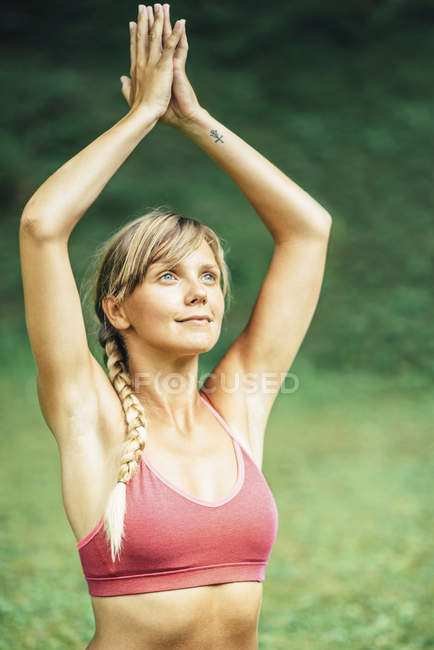 Young woman doing yoga with hands in prayer position. — Stock Photo