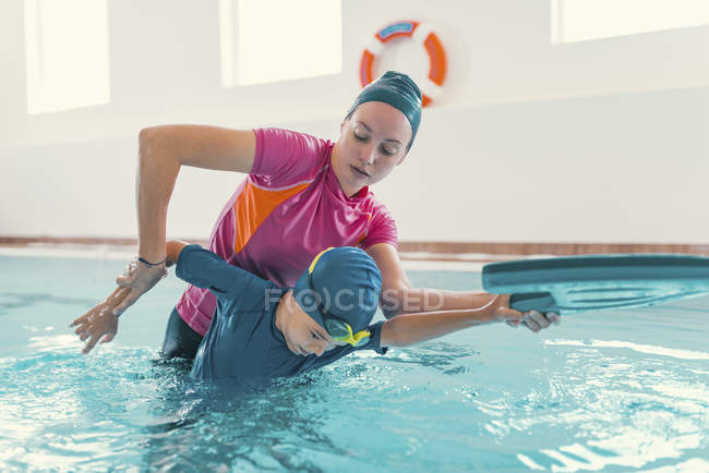 Menino na aula de natação com instrutora feminina na piscina . — Fotografia de Stock