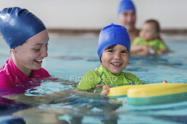 Мальчик учится плавать с инструктором в бассейне . — стоковое фото