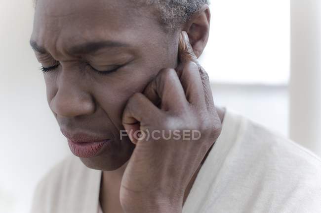 Mature woman with ear ache, close-up. — Stock Photo