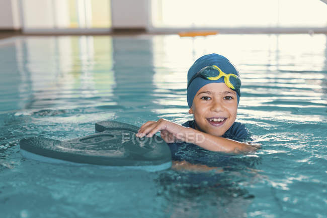Мальчик в воде бассейна во время занятий плаванием . — стоковое фото