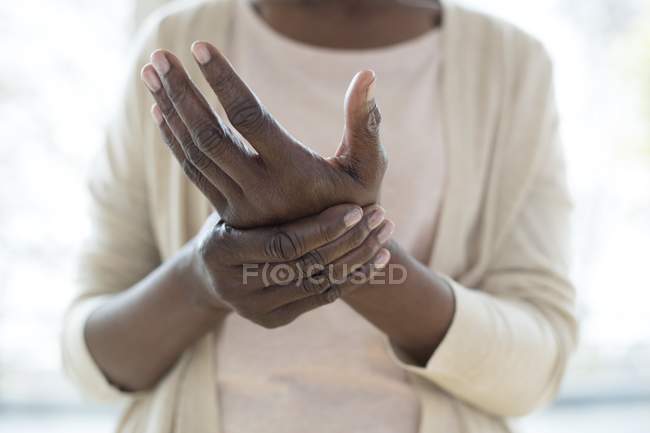 Primer plano de la mujer madura cogida de la mano con dolor . - foto de stock