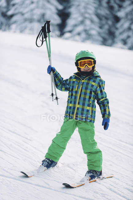 Маленький хлопчик в зимовому одязі катається на лижах на засніжених горах . — стокове фото