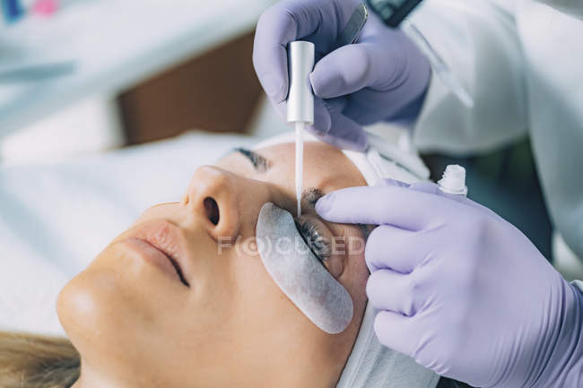 Kosmetikerin führt Wimpernlifting an Patientin im Salon durch. — Stockfoto