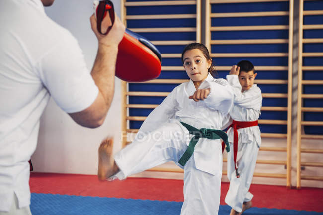 Instructeur de taekwondo formant les enfants en classe . — Photo de stock