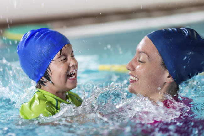 Ragazzino che fa lezione di nuoto con istruttrice femminile in piscina . — Foto stock