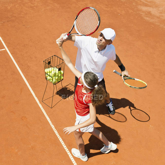 Теннисный тренер и теннисист-подросток, работающий над обслуживанием . — стоковое фото