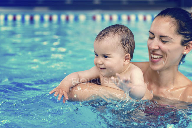 Baby boy and mother in swimming pool water. — Stock Photo