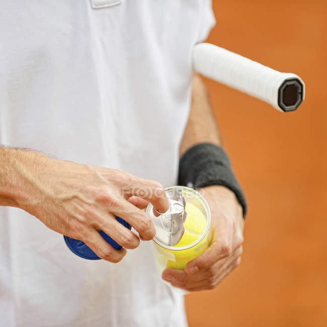 Gros plan du joueur de tennis ouvrant un nouveau pack de balles . — Photo de stock