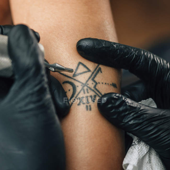 Мастер татуировки женской кожи в деталях, тонированное изображение
. — стоковое фото