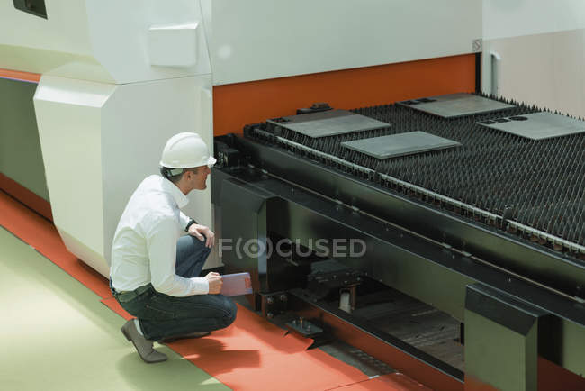 Engineer working in factory, holding check-list and supervising. — Stock Photo