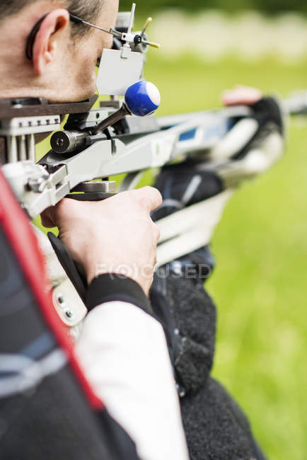 Hombre adulto practicando tiro con rifle deportivo . - foto de stock