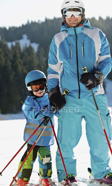 Elementary age boy having skiing lesson with father. — Stock Photo