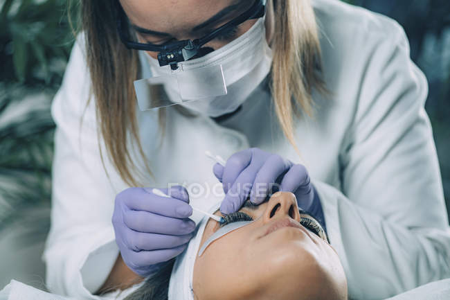 Kosmetologe reinigt Patientenaugen nach Wimpernlifting-Verfahren — Stockfoto
