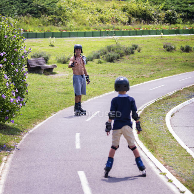 Nonno insegnamento nipote pattinaggio a rotelle nel parco . — Foto stock
