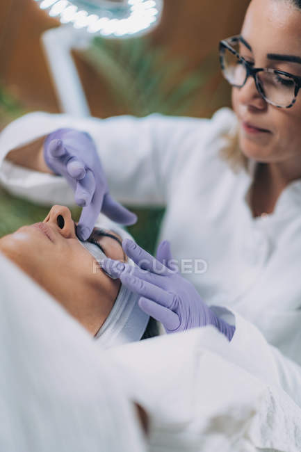 Paciente femenina sometida a procedimiento de elevación de pestañas de queratina en salón de belleza . - foto de stock