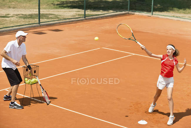 Instrutor de tênis trabalhando com estudante e praticando vôlei . — Fotografia de Stock
