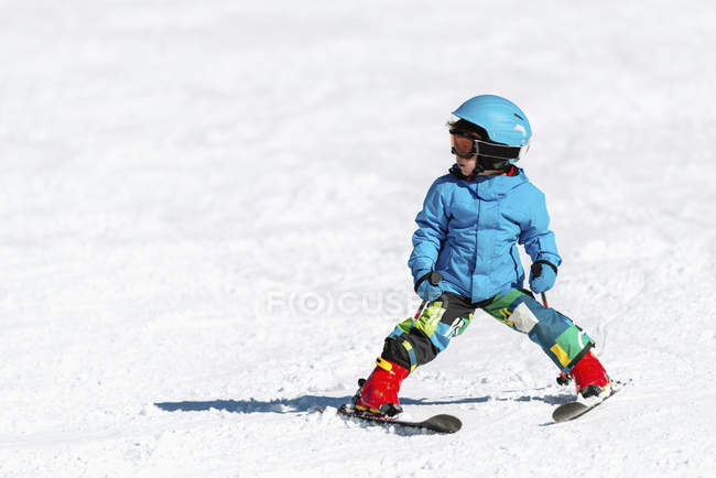 Мальчик-дошкольник катается на лыжах по снежному склону горы . — стоковое фото