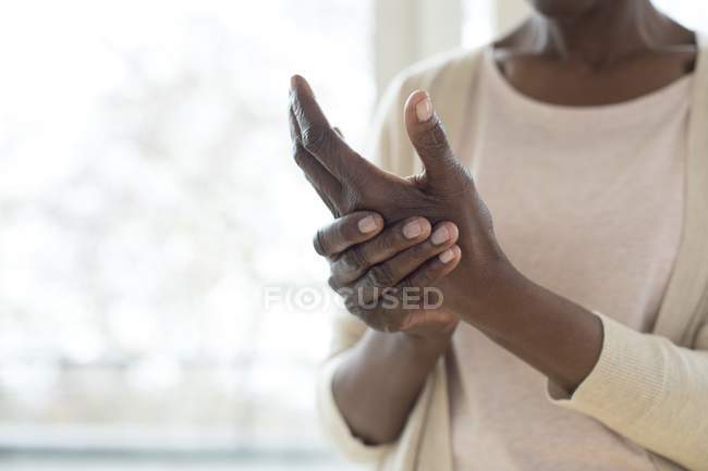 Обрізана зріла жінка з болючою рукою . — стокове фото