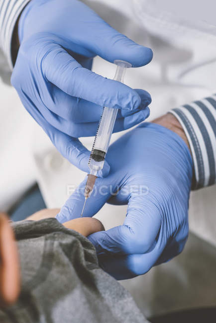Врач делает прививку от шприца дошкольнику в медицинской клинике . — стоковое фото