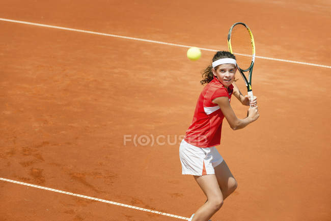 Teenage female tennis player hitting backhand stroke. — Stock Photo