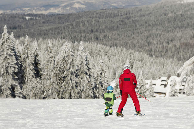 Мальчик-дошкольник катается на лыжах с мужчиной-инструктором
. — стоковое фото