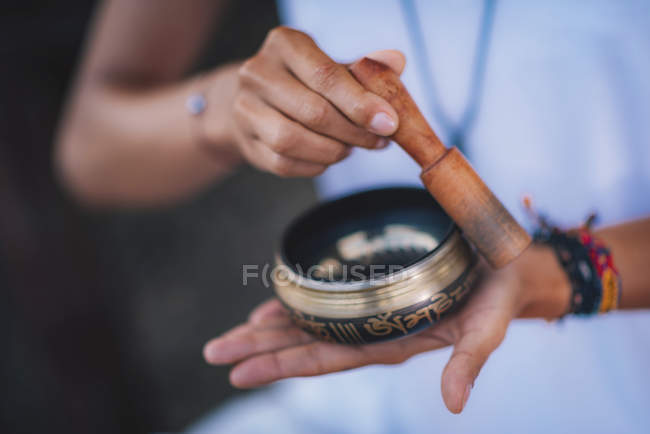 Close-up of female hands holding Tibetan singing bowl outdoors. — Stock Photo