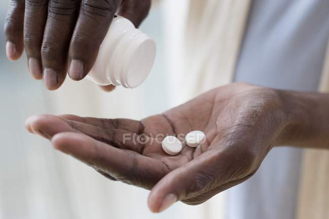 Gros plan sur les mains d'une femme mature prenant des médicaments . — Photo de stock