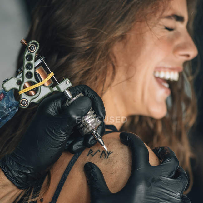 Jovem mulher recebendo ombro tatuagem . — Fotografia de Stock