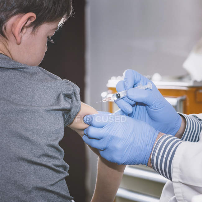 Médico fazendo vacinação seringa para menino pré-escolar na clínica médica . — Fotografia de Stock