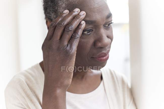 Mature woman with tension headache looking away. — Stock Photo