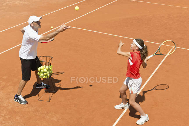 Joueur de tennis adolescent en entraînement avec entraîneur masculin . — Photo de stock