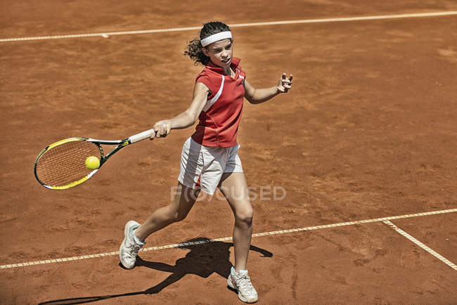 Adolescente joueuse de tennis approchant le filet pendant le match et attaquant avec le coup droit . — Photo de stock
