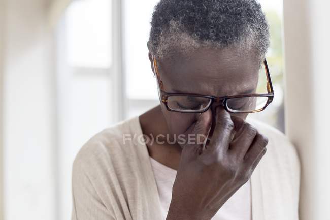 Mulher madura com dor de cabeça tensão segurando óculos . — Fotografia de Stock