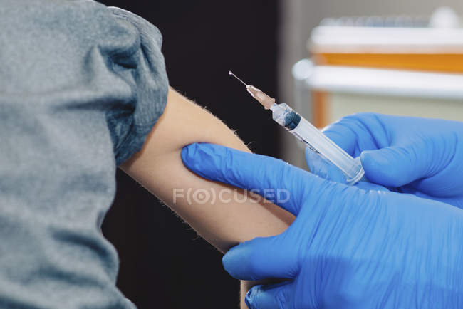 Little boy receives a vaccination in the doctors office. — Stock Photo