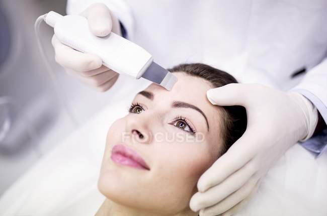 Mujer joven que recibe tratamiento de microdermoabrasión facial en clínica, primer plano
. - foto de stock