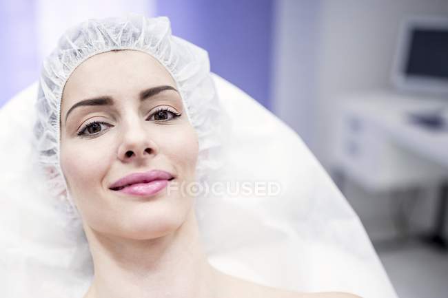 Mujer con gorra quirúrgica en clínica . - foto de stock
