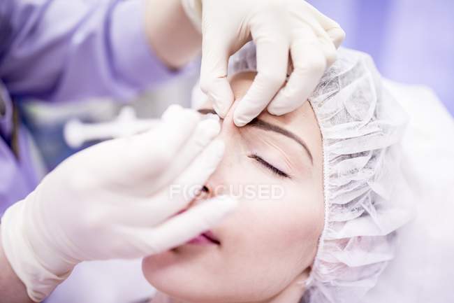 Técnico de beleza injetando botox no rosto feminino
. — Fotografia de Stock