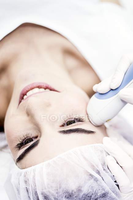 Dermatólogo dando tratamiento de eliminación de arrugas en la cara femenina, primer plano . - foto de stock