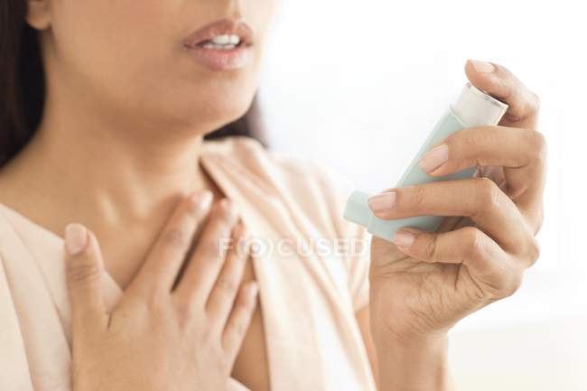 Cropped shot of woman using inhaler device. — Stock Photo