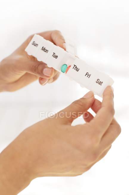 Cropped shot of hands of woman holding pill organizer. — Stock Photo