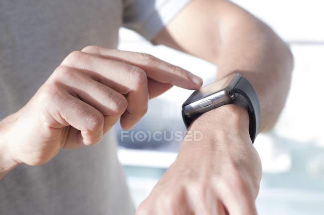 Hands of man checking smartwatch, close-up. — Stock Photo