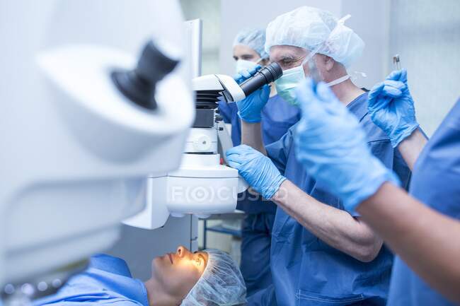 Equipo quirúrgico que realiza cirugía ocular láser. - foto de stock