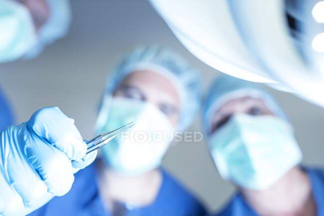 Equipo quirúrgico inclinado sobre un paciente. - foto de stock