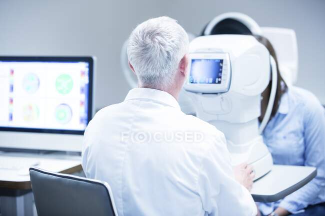 Topographie cornéenne. Ophtalmologiste scannant l'œil d'un patient pour obtenir une image tridimensionnelle de la cornée. — Photo de stock
