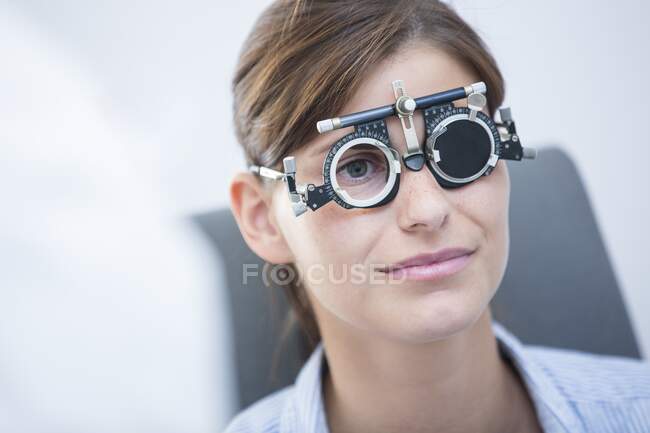 Exame ocular. Mulher usando quadros de julgamento durante um exame ocular. — Fotografia de Stock