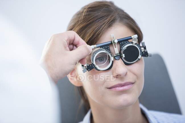 Проверка зрения. Женщина в пробных рамах во время осмотра глаз. — стоковое фото