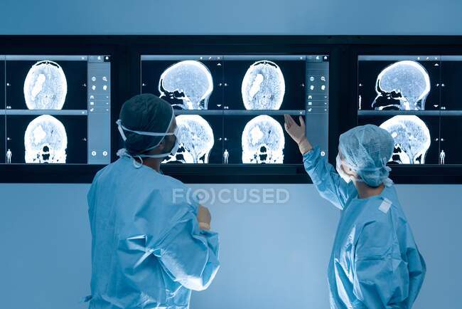 Хирурги, изучающие магнитно-резонансную томографию (МРТ) мозга во время операции на мозге. — стоковое фото
