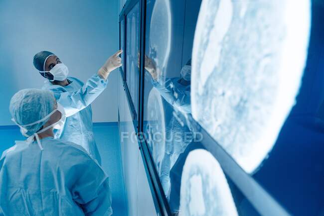Cirurgiões que olham para imagens de ressonância magnética (MRI) exames cerebrais durante a cirurgia cerebral. — Fotografia de Stock